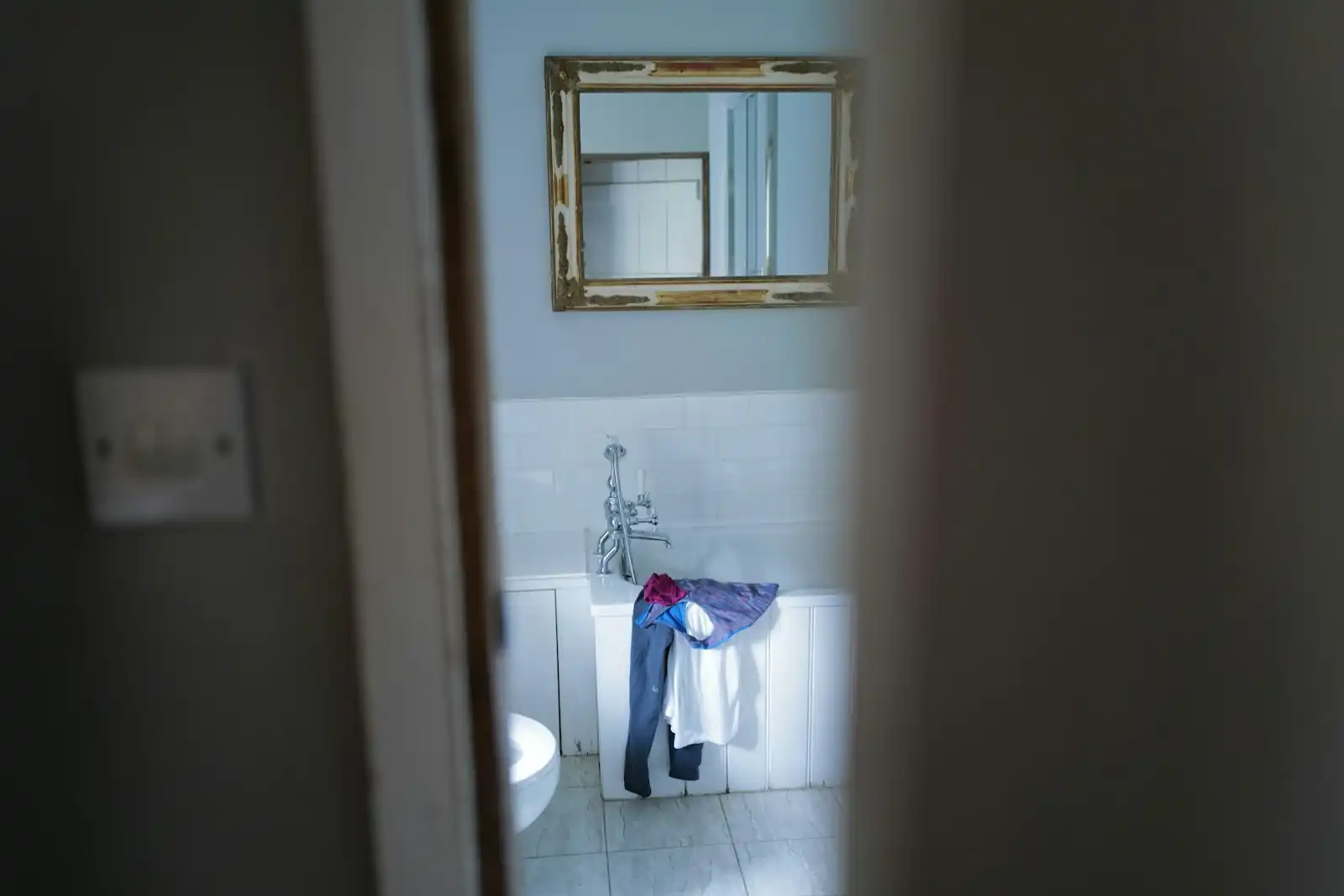 A bathroom fit-out in progress with sink and mirror installed